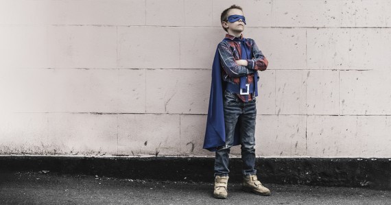 young boy in superhero cape costume